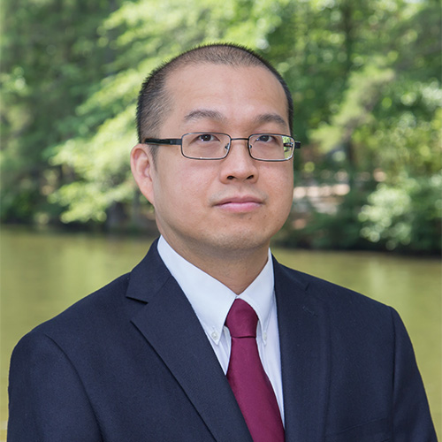 Angkul Kongmunvattana wears a red tie with his suit and glasses