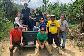 Ingrid Davis-Colato on the back of a truck stopped on a dirt road with a handful of other people with her.