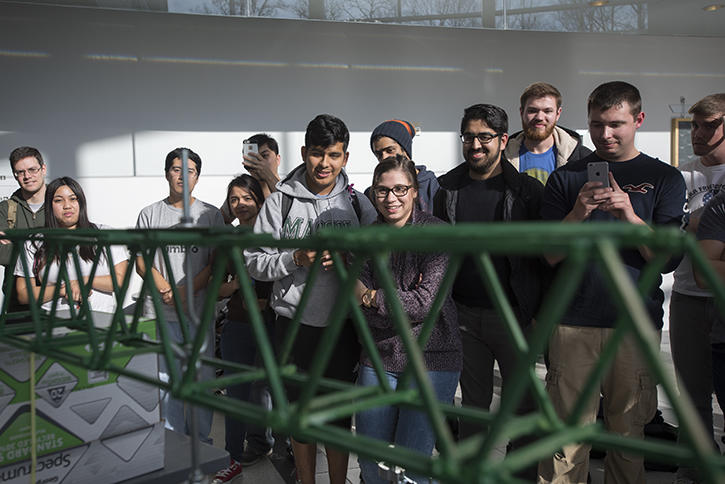 Students watch as a steel structure demonstration goes on.