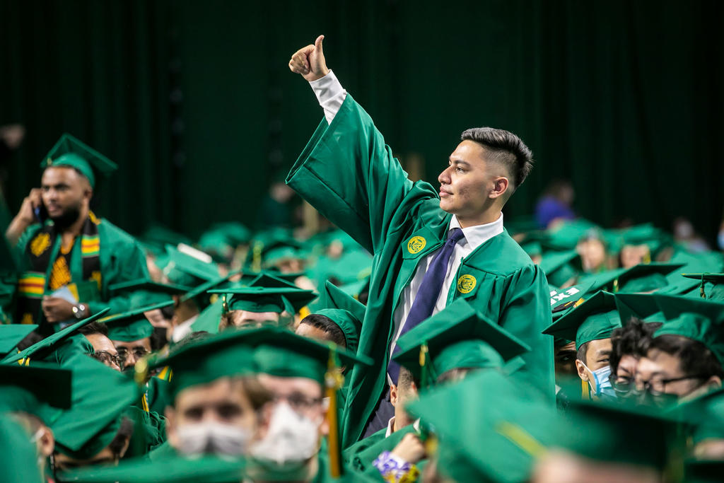 CEC graduate giving a thumbs up to his family