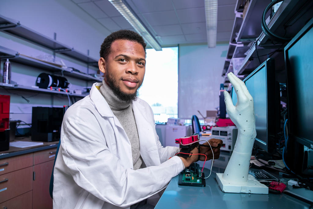 Quentin Sanders, bioengineering professor, in his lab demonstrating the exoskeleton mechanical hand