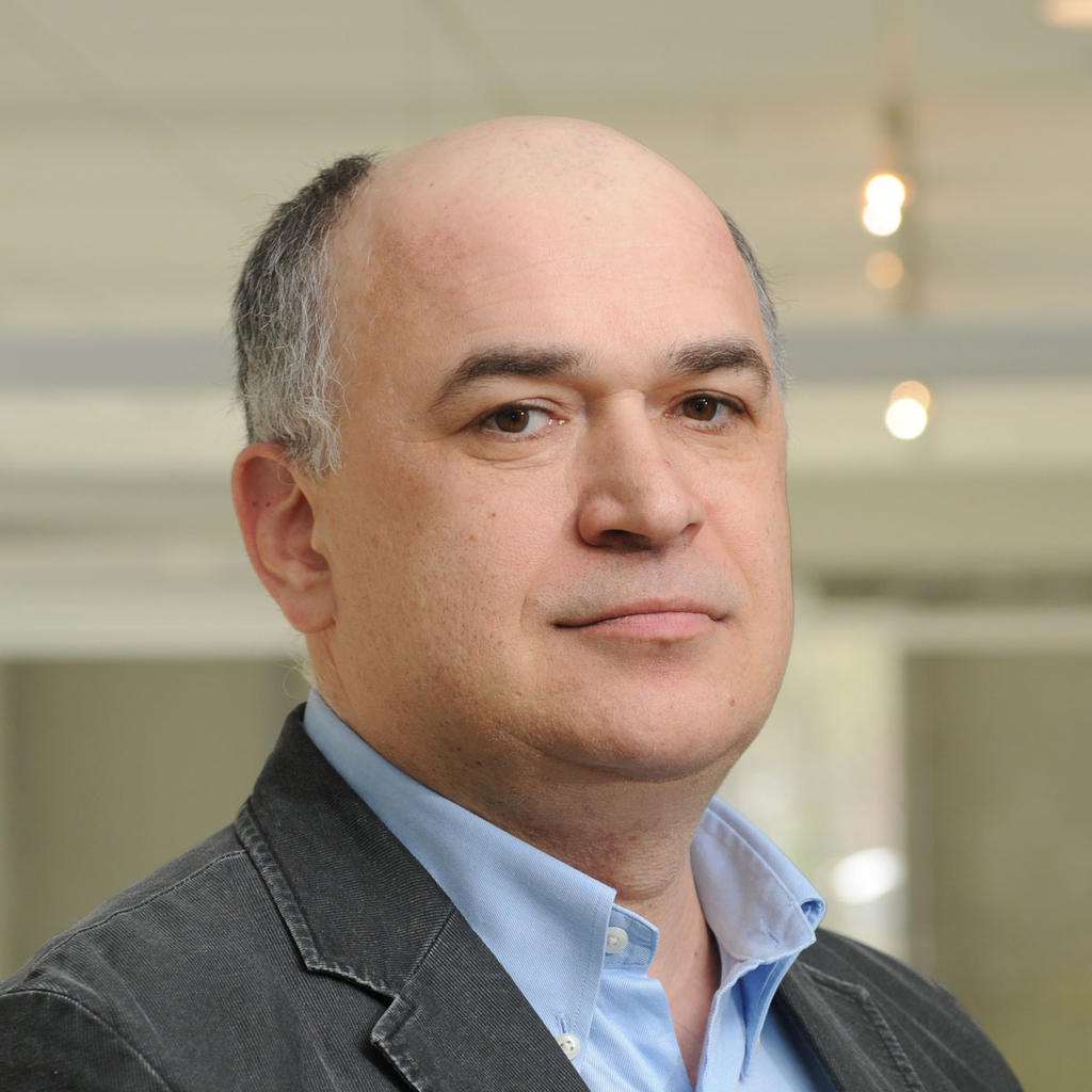 Zoran Doric wears a blue shirt and gray blazer in his headshot for his profile.