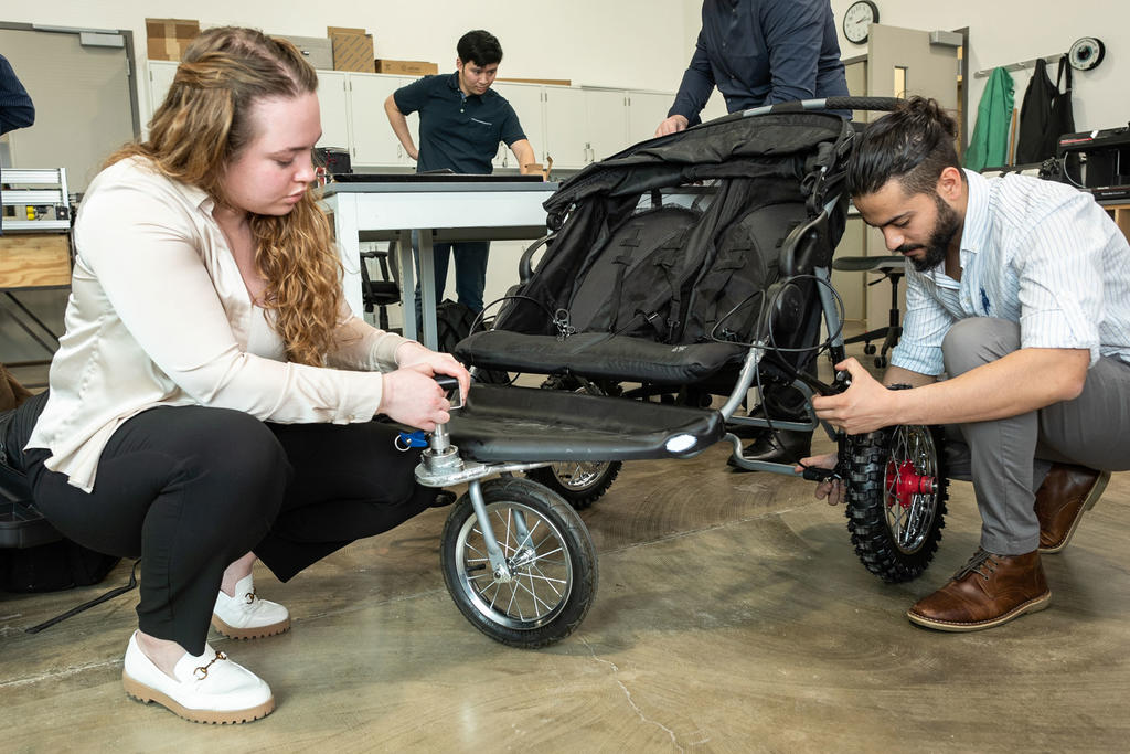 A male student and female student assemble a mobile chair for their engineering design project