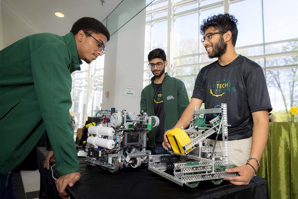 Male students showcase their robots at the Whiskey, Widgets, and Wonks event