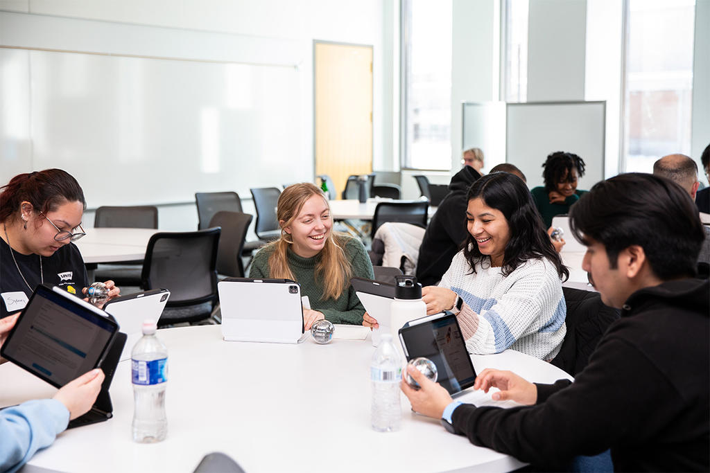 Female students sit and work on a project at the STEM Accelerator Workshop for George Mason University