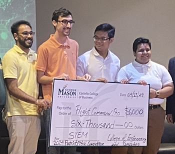 Four college student contest winners hold a check