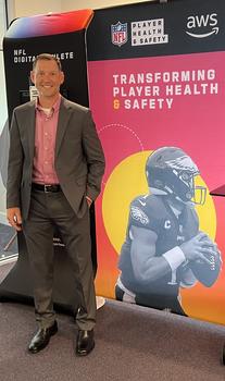 A man stands next to an NFL backdrop about player safety