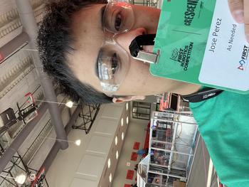 A high school student holds a name badge for a FIRST Robotics competition