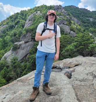 Young man stands on a rocky trail