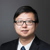 Mason assistant professor Ran Ji wears a black suit, striped-blue tie, and glasses in his profile