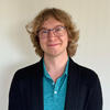 CS professor Greg Stein has long blonde hair and wears a blue, collared shirt
