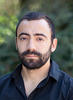 Mason assistant professor Antonios Anastasopoulos wears a dark, collared shirt and has a dark hair and beard in his profile